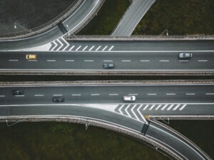 Aerial drone view of highway road intersection with cars in Italy
