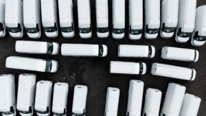 Aerial view directly above a stockpile of new white vans ready for export