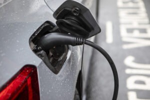 Raindrops on the bodywork of an electric car parked in an electric vehicle charging bay on a London street