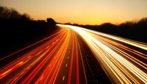 Dynamic light trails illuminate a highway at dusk, capturing the essence of speed and movement