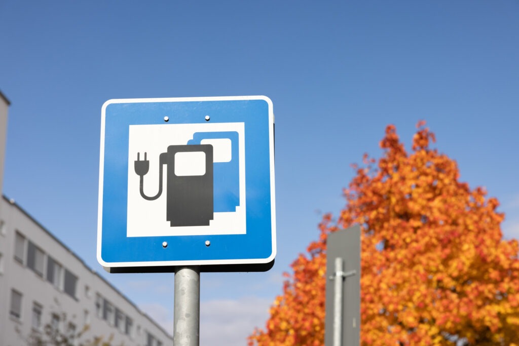 Ladestation für Elektrofahrzeuge singen auf der Straße mit Natur und blauem Himmelshintergrund.