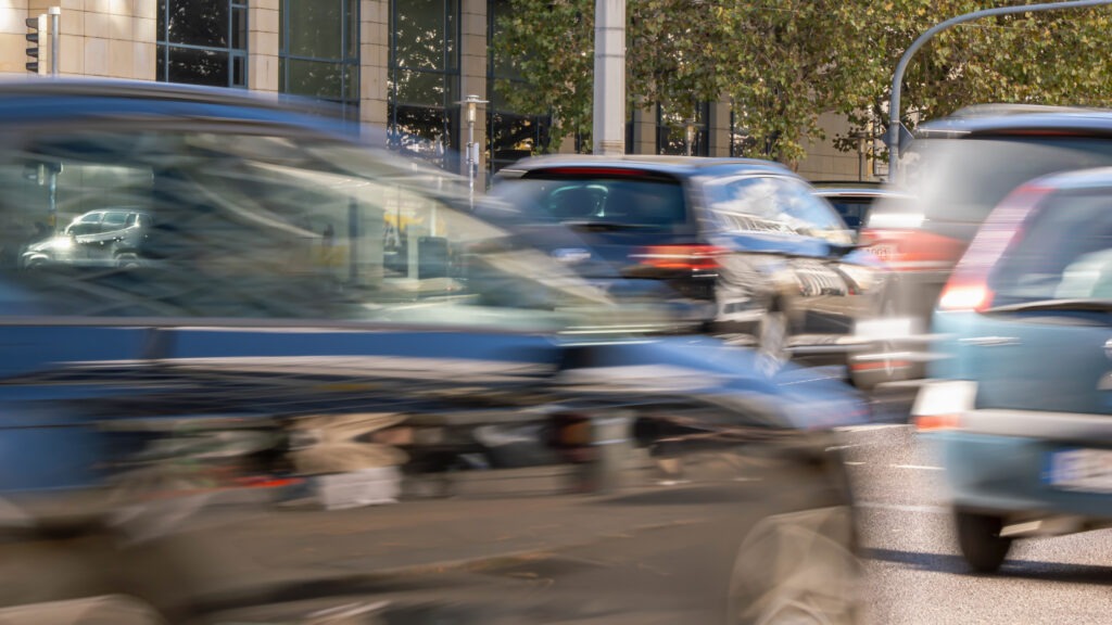 blurred driving cars outdoors on city street, close-up of traffic jam background with motion blur in daylight