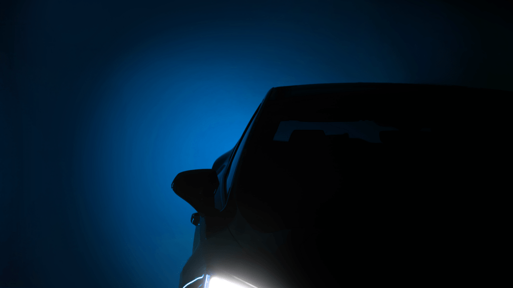 Dunkle Grafik eines Silhouettenautos und Scheinwerfern