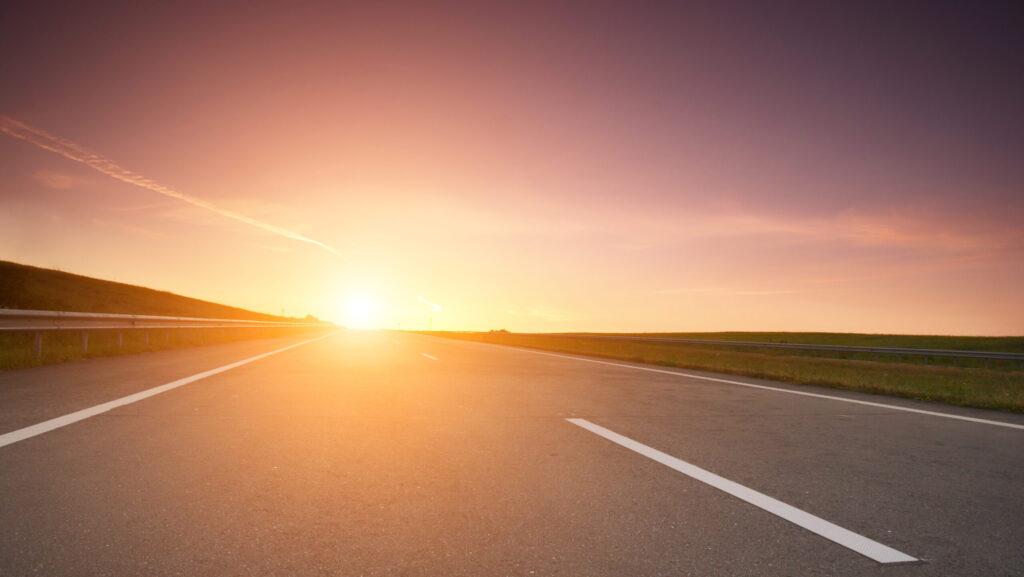 Highway with the rising sun on the horizon